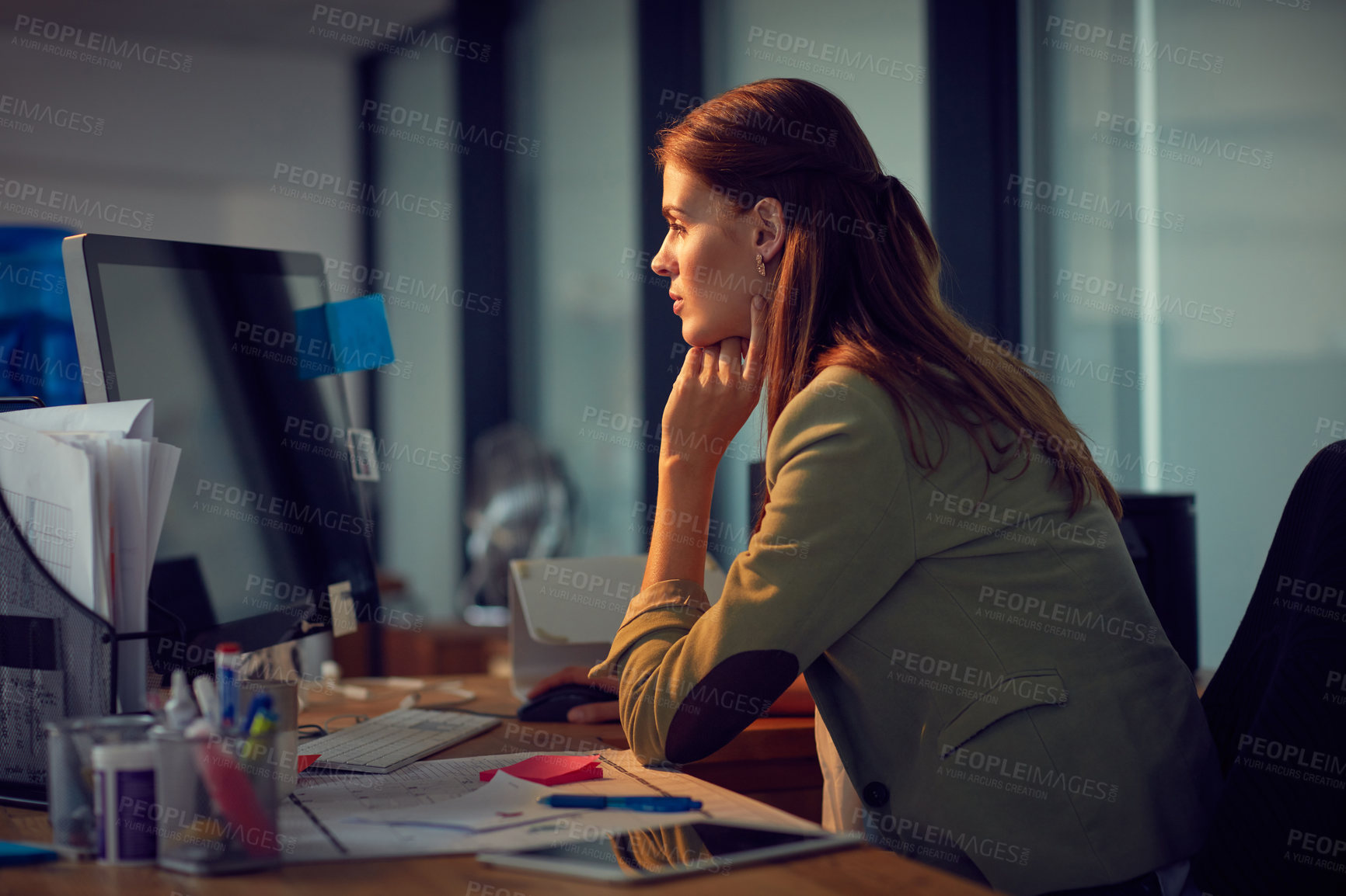 Buy stock photo Shot of a young businesswoman using a computer during a lat night at work
