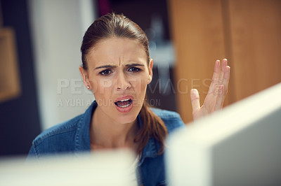 Buy stock photo Shot of a young businesswoman using a computer and looking angry in a modern office