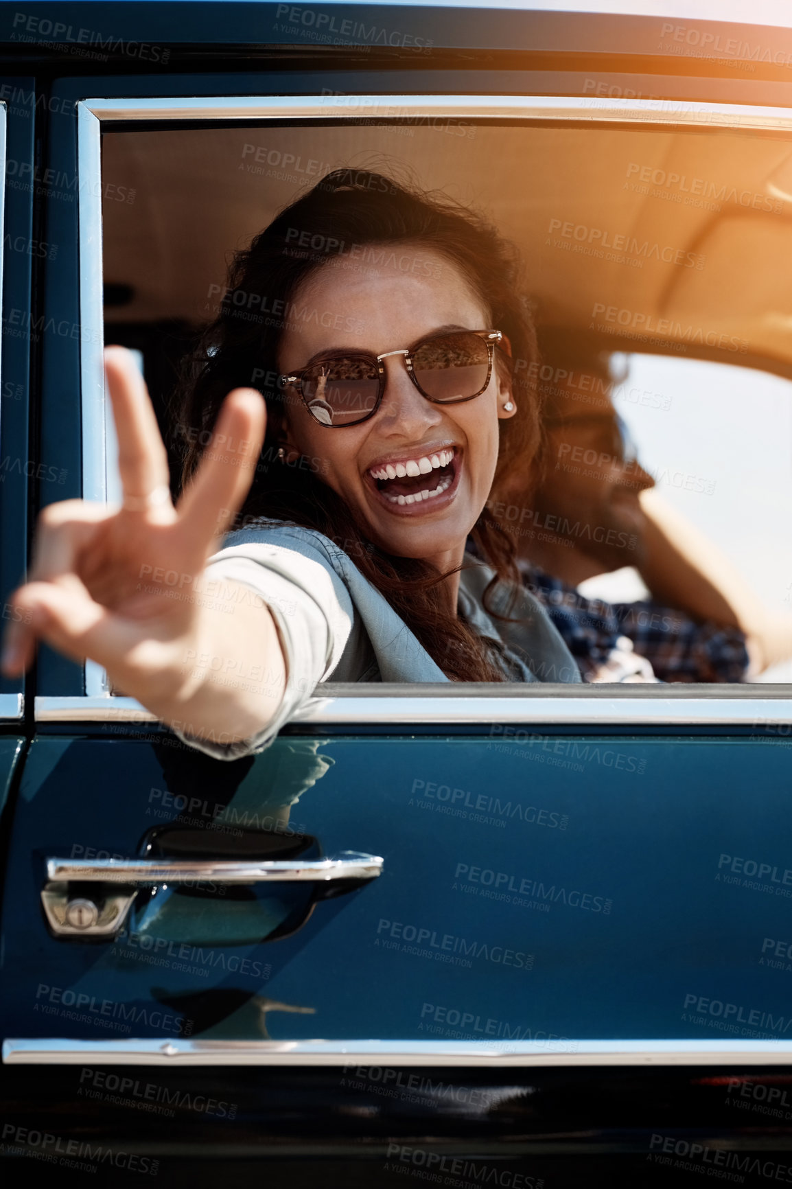 Buy stock photo Cropped portrait of an attractive woman giving you a peace sign while enjoying a roadtrip