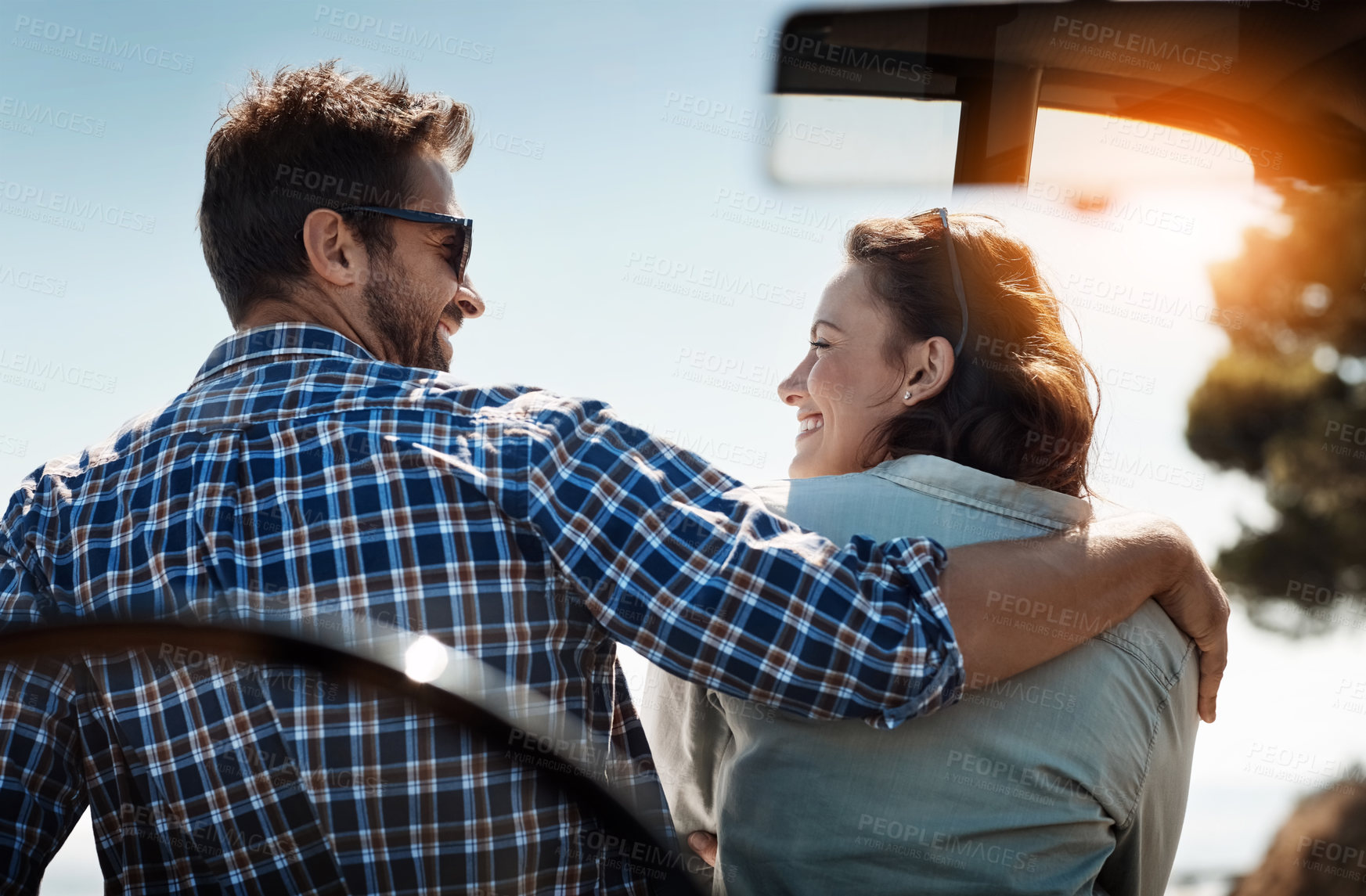 Buy stock photo Rearview shot of an affectionate couple taking in the sights while enjoying a road trip