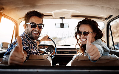 Buy stock photo Rearview portrait of an affectionate couple giving you a thumbs up while enjoying a road trip