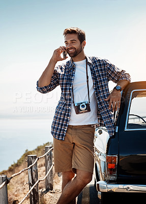 Buy stock photo Shot of a handsome man talking on his cellphone while out on a road trip