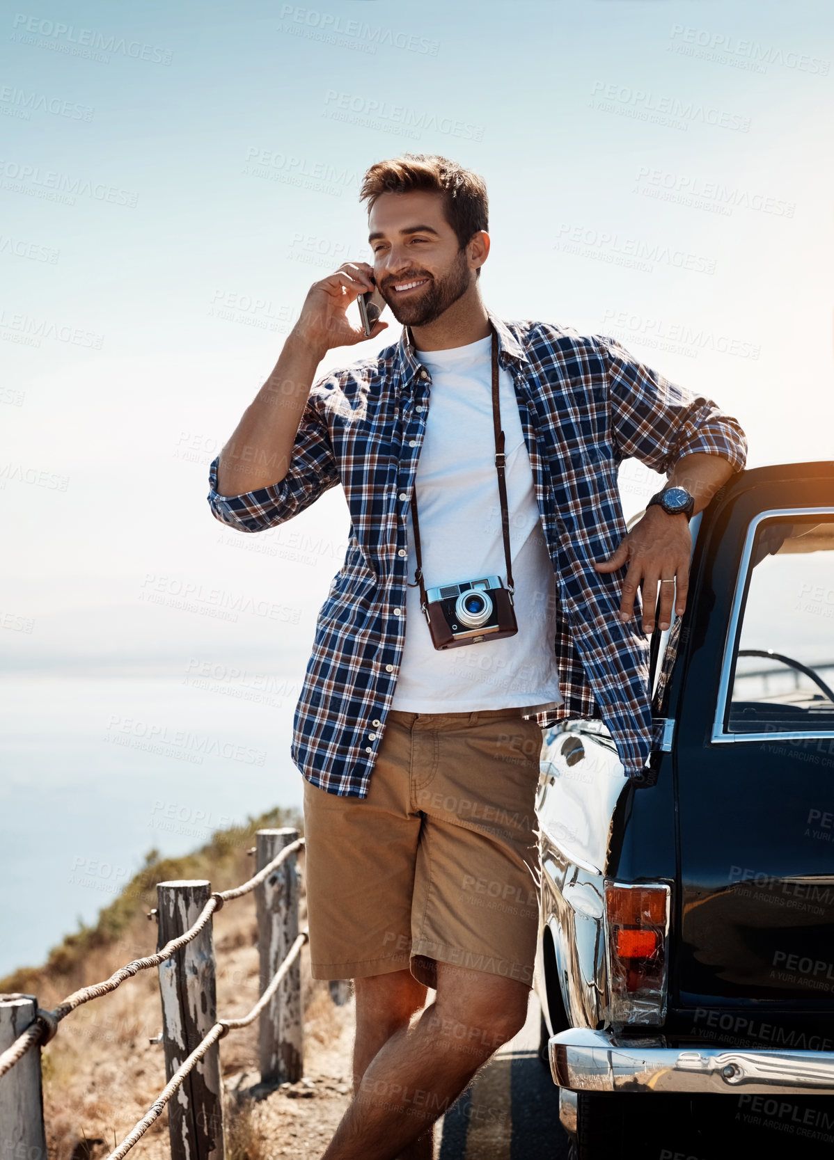 Buy stock photo Shot of a handsome man talking on his cellphone while out on a road trip