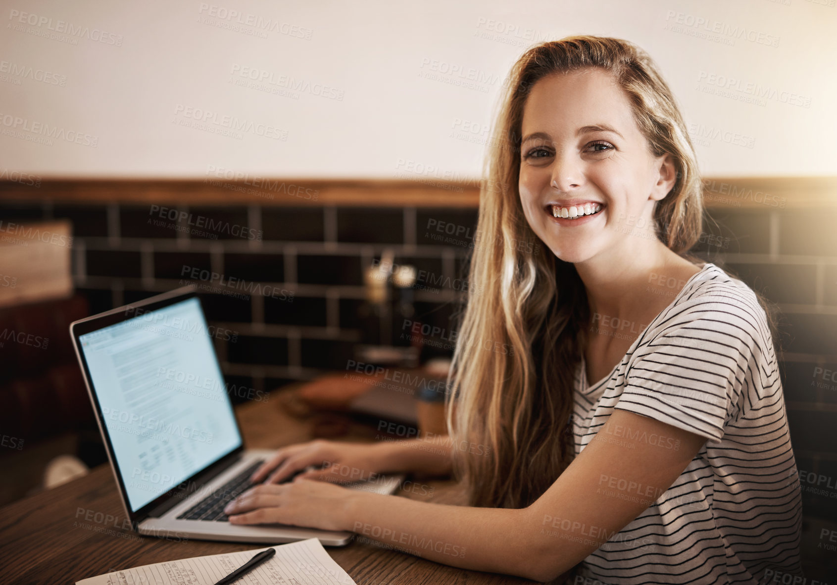 Buy stock photo Cropped portrait of a happy young student using her laptop to study at a tablet in a cafe