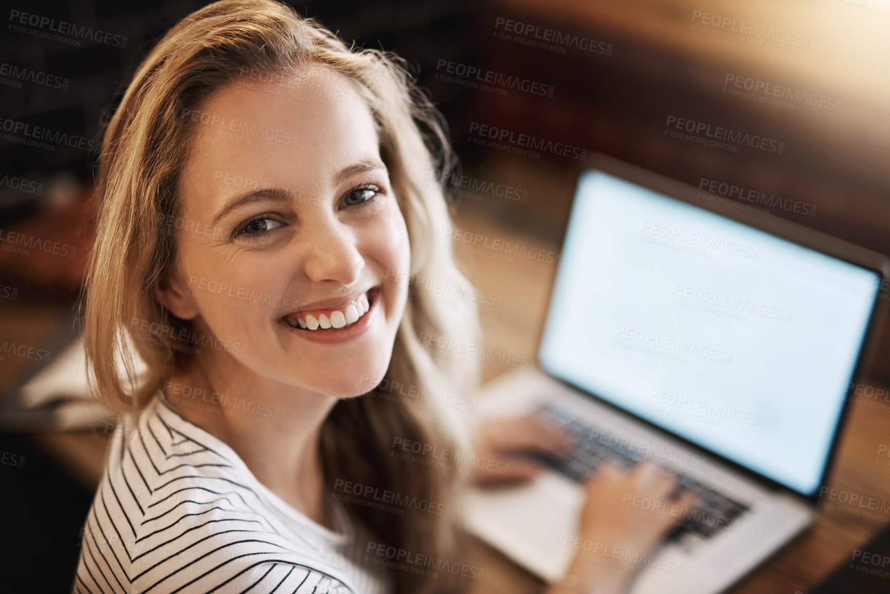 Buy stock photo High angle portrait of a happy young student using her laptop to study at a tablet in a cafe