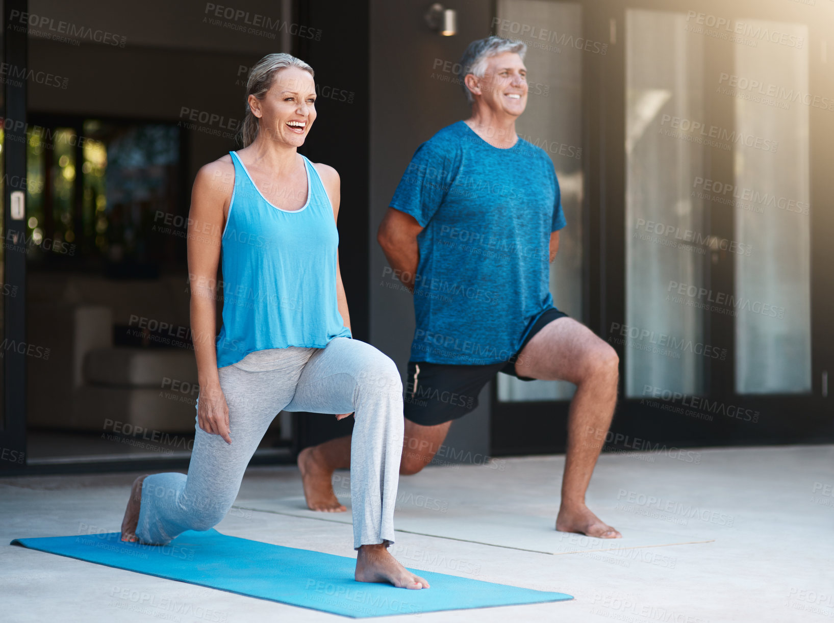 Buy stock photo Full length shot of a mature and happy couple doing yoga exercise outside of their home
