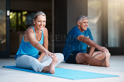 Buy stock photo Shot of a mature and happy couple stretching before they begin their yoga session outside of their home
