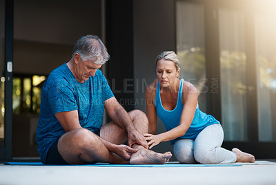 Buy stock photo Shot of a mature man holding his ankle in pain after an intense workout session with his wife