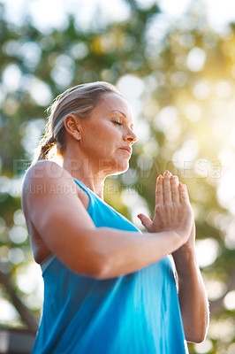 Buy stock photo Low angle shot of a mature woman meditating outdoors