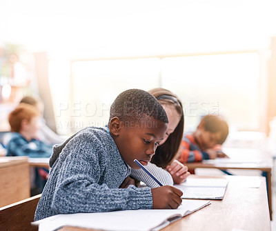 Buy stock photo Cropped shot of two elementary school kids doing school work inside of the class during the day