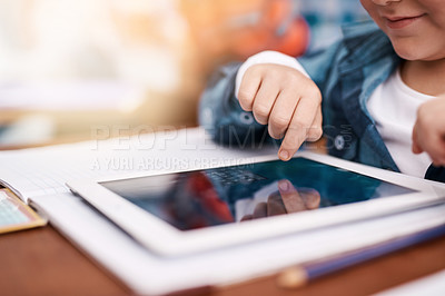 Buy stock photo Cropped shot of a unrecognizable elementary school kid browsing on a digital tablet in the classroom