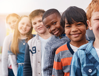 Buy stock photo Portrait of a group of cheerful elementary school kids standing behind each other while looking at the camera