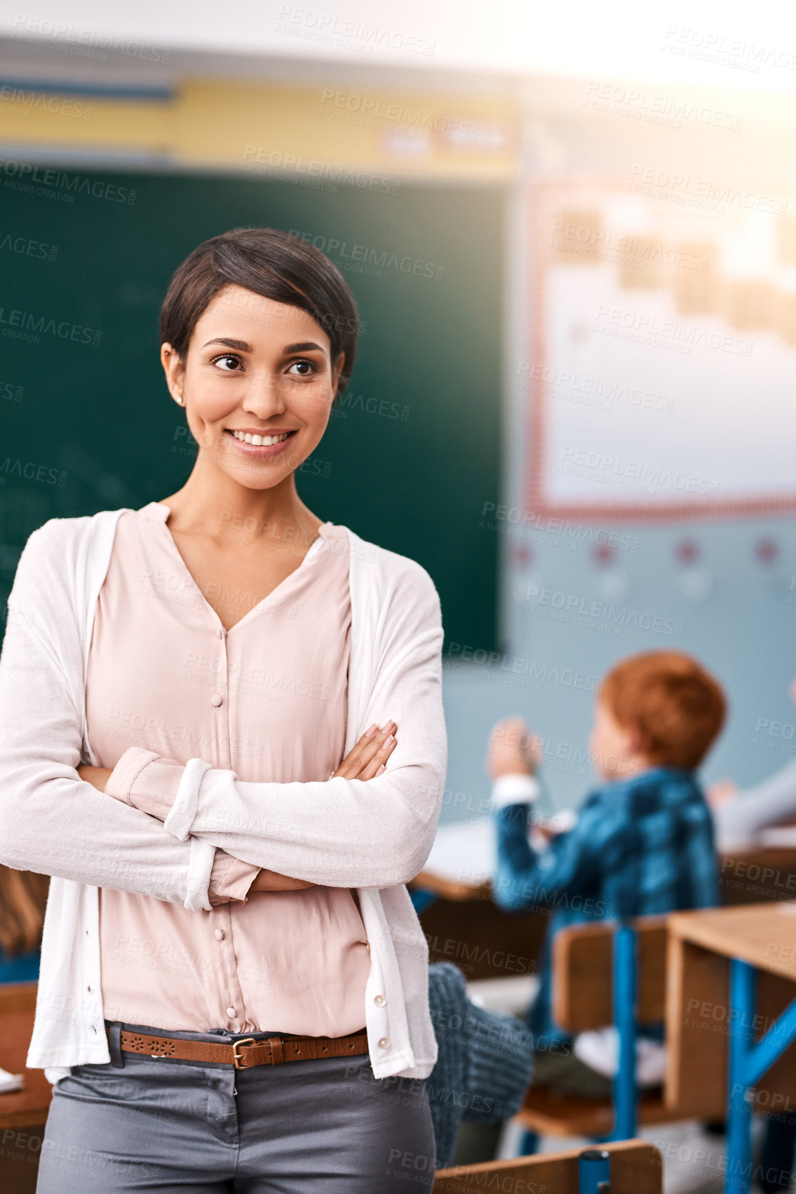 Buy stock photo Woman, teacher and happy with arms crossed in classroom for teaching, learning and education in elementary school. Female person, professional and smile or proud in confidence with career growth