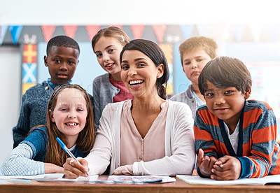 Buy stock photo Portrait of a cheerful young female teacher helping her students inside of the class at school