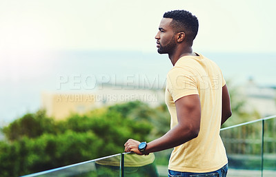 Buy stock photo Shot of a handsome young man looking at the scenery while relaxing outdoors on holiday