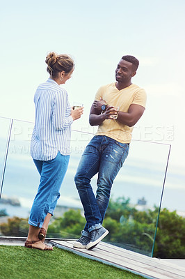 Buy stock photo Full length shot of a young couple enjoying drinks together while relaxing outdoors on holiday
