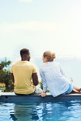 Buy stock photo Rearview shot of a young couple enjoying drinks together while relaxing outdoors on holiday