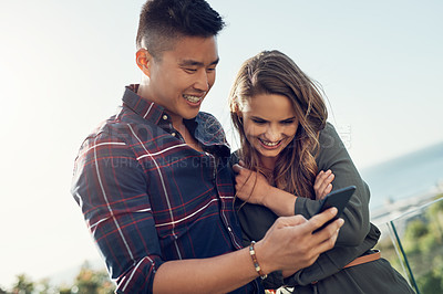 Buy stock photo Shot of an attractive young woman making funny faces while her boyfriend takes pictures of her outdoors