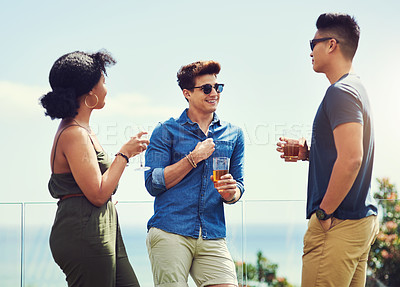 Buy stock photo Shot of a group of friends having drinks and enjoying themselves outdoors while on holiday