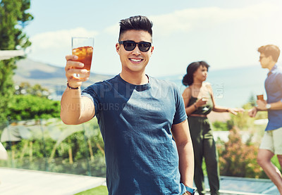 Buy stock photo Portrait of a handsome young man raising up his glass for a toast while relaxing outdoors with his friends