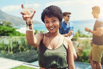 Buy stock photo Portrait of an attractive young woman raising up her glass for a toast while relaxing outdoors with her friends