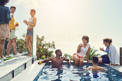 Buy stock photo Shot of a group of friends having drinks and enjoying themselves poolside on holiday