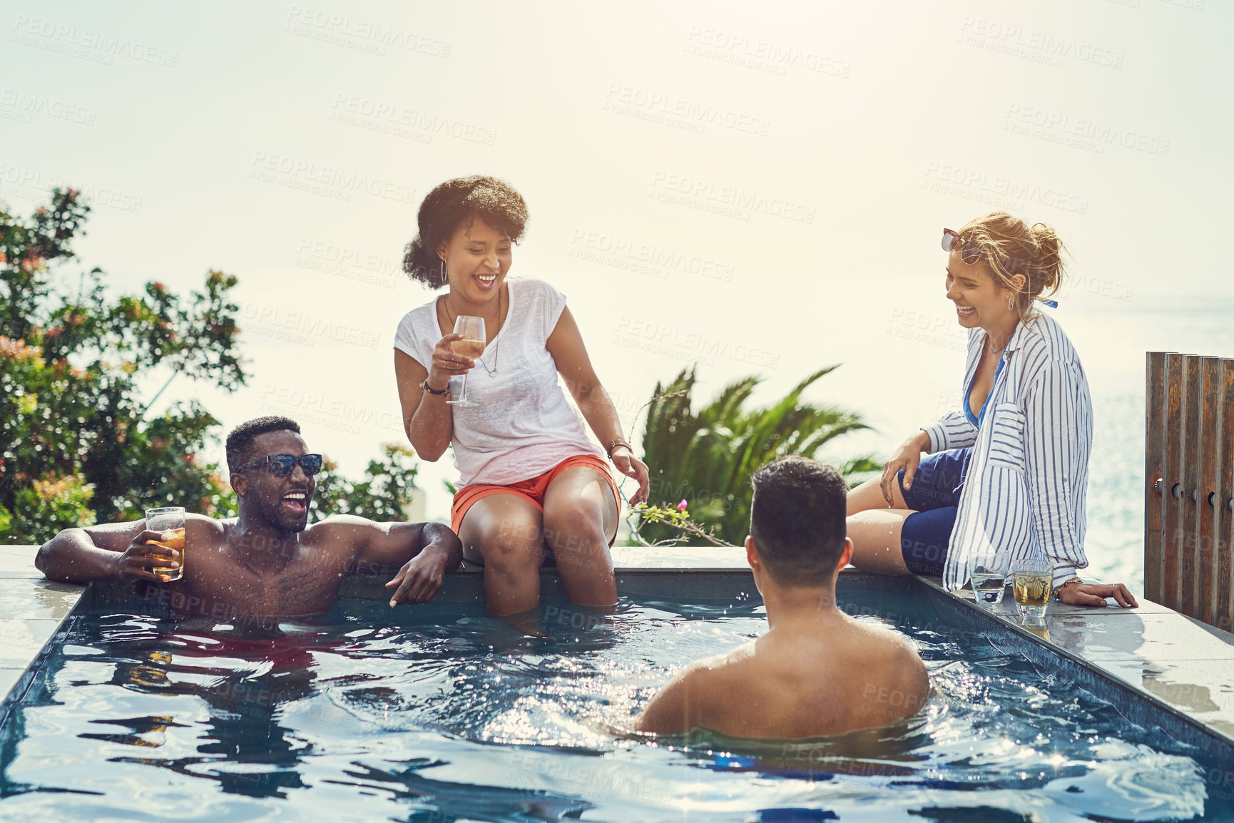 Buy stock photo Friends, drinks and happy at party in swimming pool with memory, funny chat and blue sky in summer. Men, women and people in group in water, relax and comic conversation with alcohol at social event