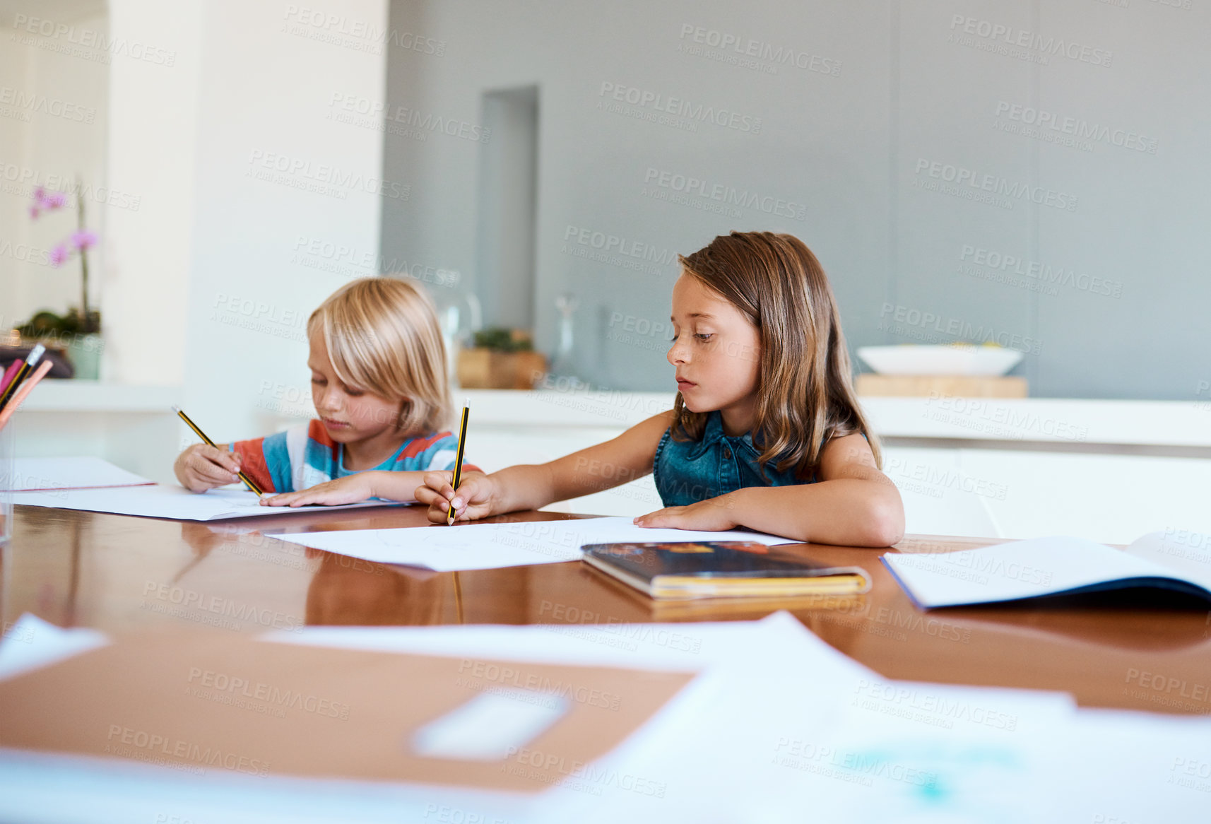 Buy stock photo Shot of two adorable young children doing their homework together at home