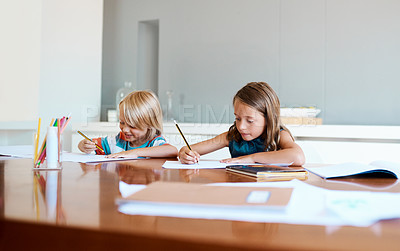 Buy stock photo Shot of two adorable young children doing their homework together at home