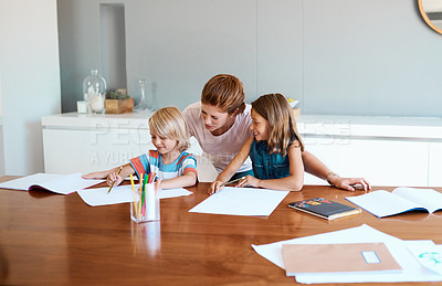 Buy stock photo Shot of a young mother helping her two small children with their homework at home
