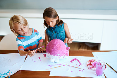Buy stock photo Shot of two adorable little children working on an art project together at home