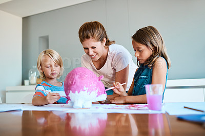 Buy stock photo Shot of a young mother helping her two small children with their art project at home
