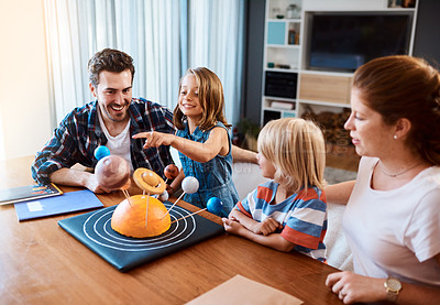 Buy stock photo Shot of a beautiful young family working together on a science project at home