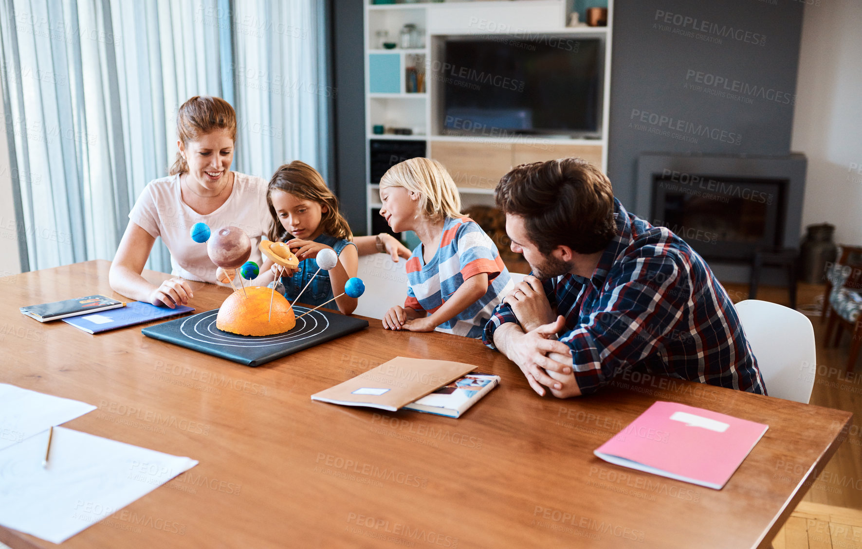 Buy stock photo Shot of a beautiful young family working together on a science project at home