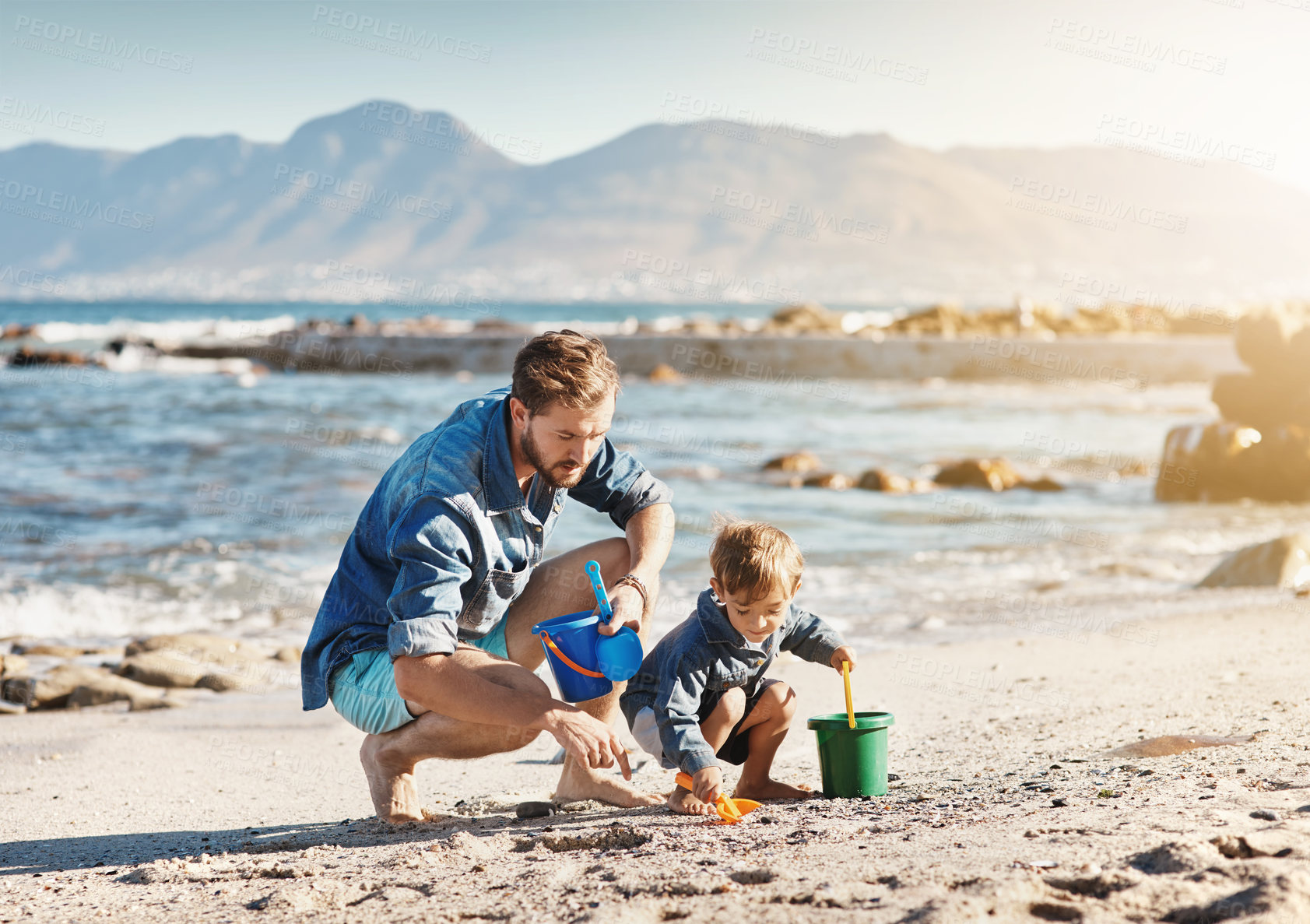 Buy stock photo Family, beach and fun with dad help and child together with sandcastle and vacation. Outdoor, toys and summer holiday with sea and travel with love, youth care and support with learning by ocean 