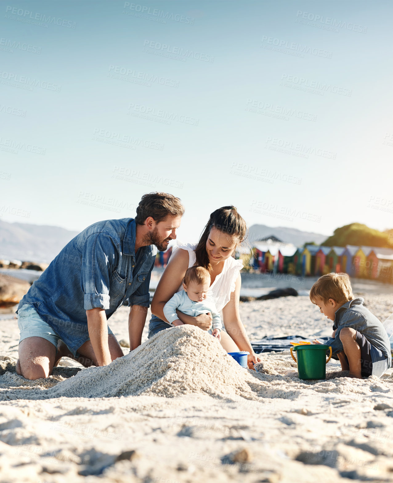 Buy stock photo Sandcastle, holiday and children at the beach with family, love and support. Baby, mom and dad together with kids playing in the sun with happiness and smile by the ocean and mockup with bonding