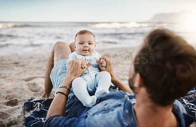 Buy stock photo Shot of a father bonding with his baby son at the beach