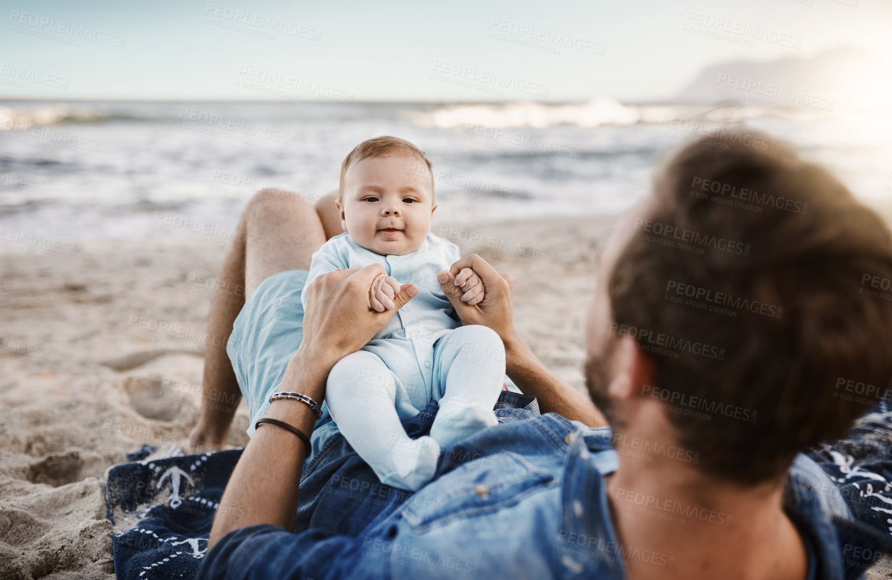 Buy stock photo Shot of a father bonding with his baby son at the beach