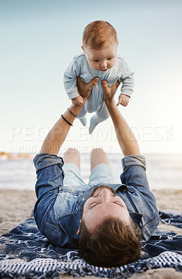 Buy stock photo Beach, sand and dad with lifting baby on towel for summer vacation, bonding and child development. Family, adventure and man with infant by ocean for fathers day, love and outdoor holiday in Florida