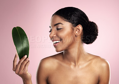 Buy stock photo Woman, smile and leaf of skincare in studio, pink background and eco friendly facial cosmetics. Face, happy and african model with natural beauty, green plants and sustainability of vegan dermatology