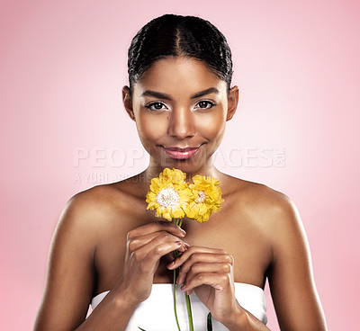 Buy stock photo Portrait, woman and flowers for skincare in studio, pink background and eco friendly cosmetics. Face, african model and natural beauty with yellow daisy, plants and sustainability for floral blossom