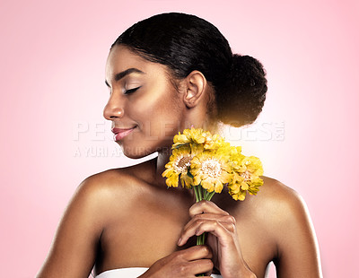 Buy stock photo Woman, face and flowers for skincare in studio, pink background and eco friendly makeup cosmetics. African model, natural beauty and yellow daisy plants for sustainability, floral blossom and perfume