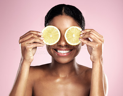 Buy stock photo Happy woman, beauty and eyes with lemon in studio, pink background and vitamin c benefits. Face, african model and fun with citrus fruits for natural skincare, vegan cosmetics and facial aesthetic 