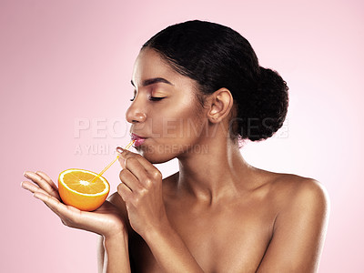Buy stock photo Orange, juice and woman with drink in studio for vitamin c benefits in skincare or dermatology. Citrus, fruit and breakfast for healthy nutrition, diet and natural beauty with organic cosmetics