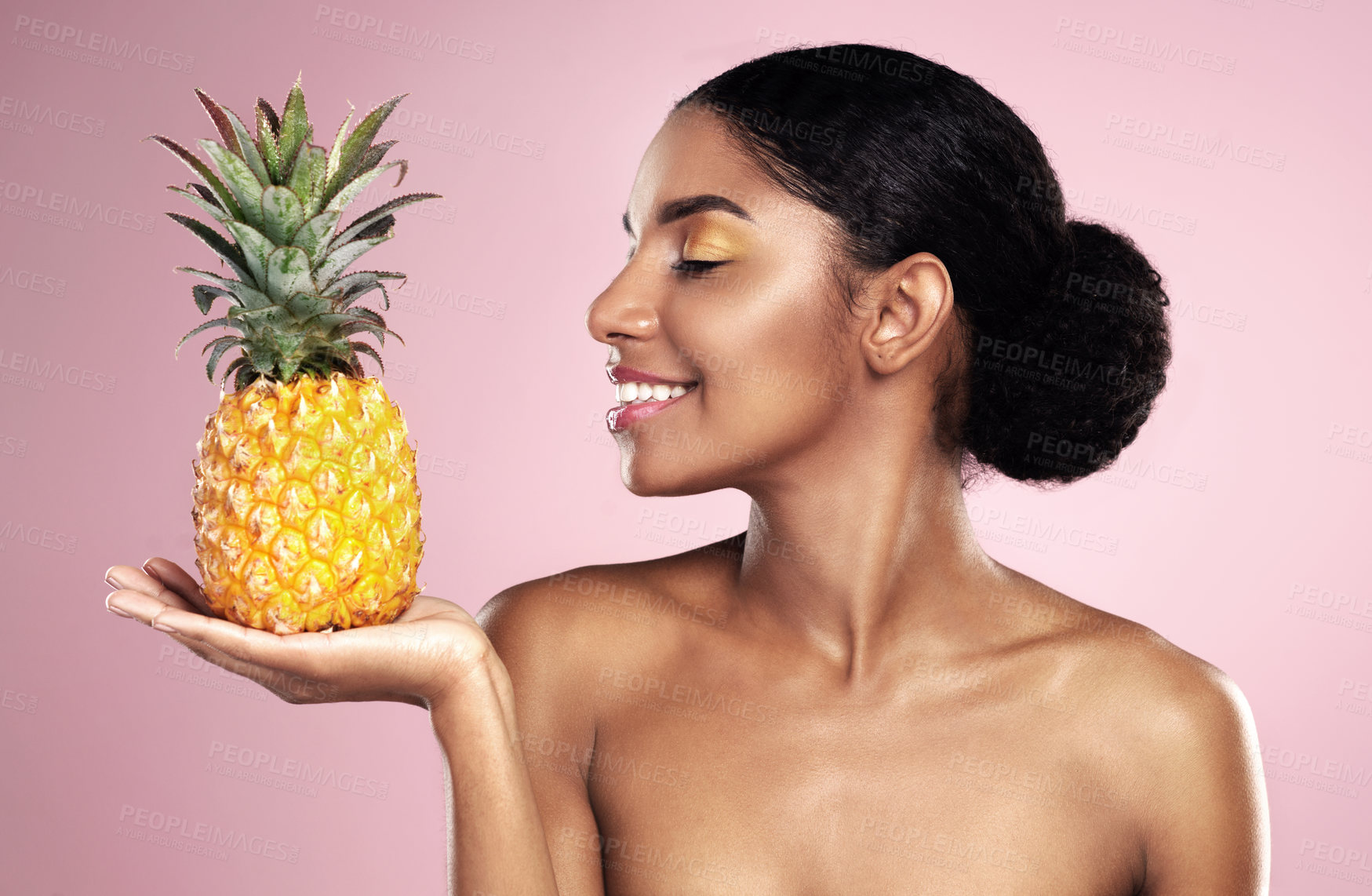Buy stock photo Woman, pineapple and smile for beauty in studio, pink background and healthy vitamin c cosmetics. Happy african model, tropical fruits and nutrition for natural skincare, organic benefits and detox
