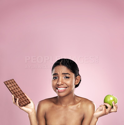 Buy stock photo Black woman, health and nutrition with food choice for balanced diet isolated in studio. Happy, female person or model and chocolate or apple option for weight loss and wellness on pink background