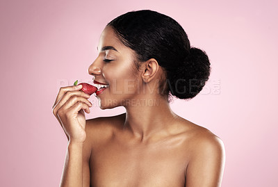 Buy stock photo Eating, profile and black woman with strawberry for nutrition, health and healthy diet isolated on pink background. Skin, gen z girl with fruit for food, wellness and happy on studio backdrop