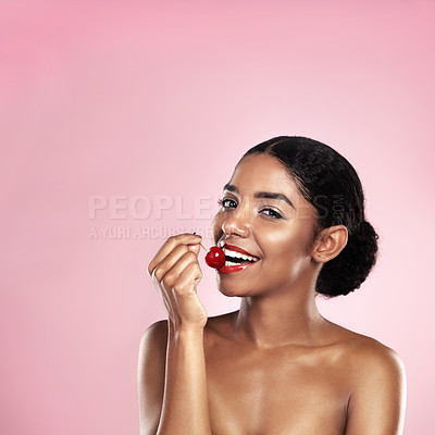 Buy stock photo Eating, portrait and black woman with cherry for nutrition, health and healthy diet isolated on pink background. Skin, gen z and girl with fruit for food, wellness and happy on studio backdrop