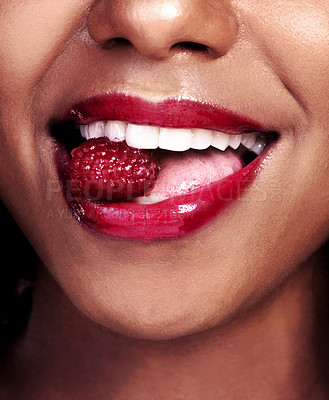 Buy stock photo Biting, mouth and black woman with raspberry for nutrition, health and healthy diet isolated on dark background. Closeup, gen z girl with fruit for food, wellness and happy on studio backdrop