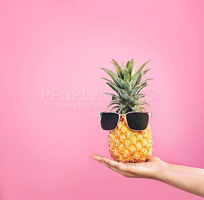 Buy stock photo Cropped shot of a woman holding a pineapple with sunglasses on